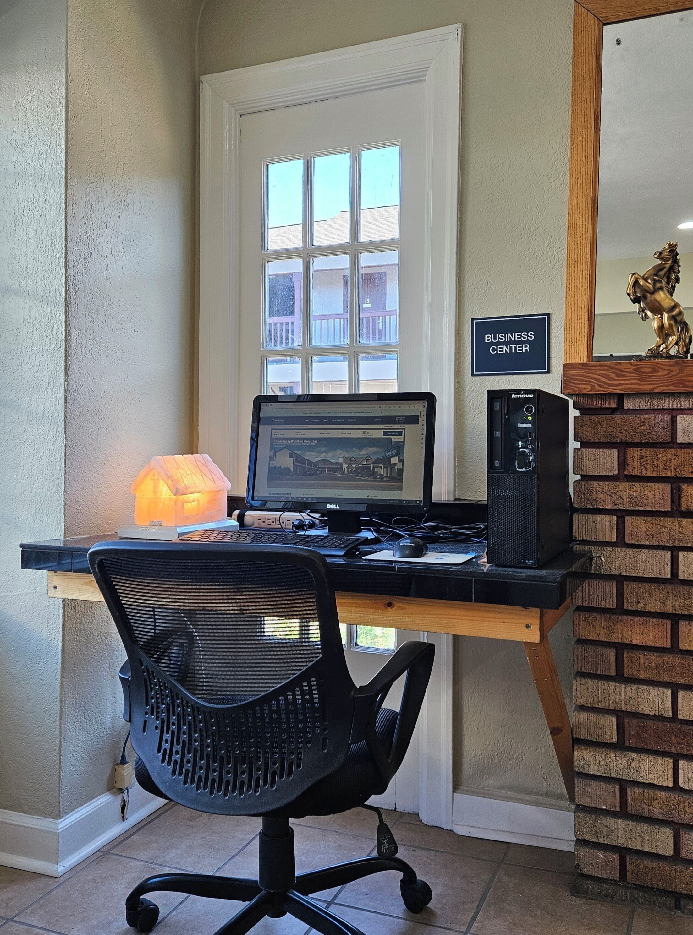 Een werkplek aan huis met een laptop, een desktopcomputer en een stoel.