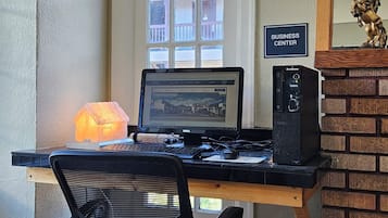 Een werkplek aan huis met een laptop, een desktopcomputer en een stoel.