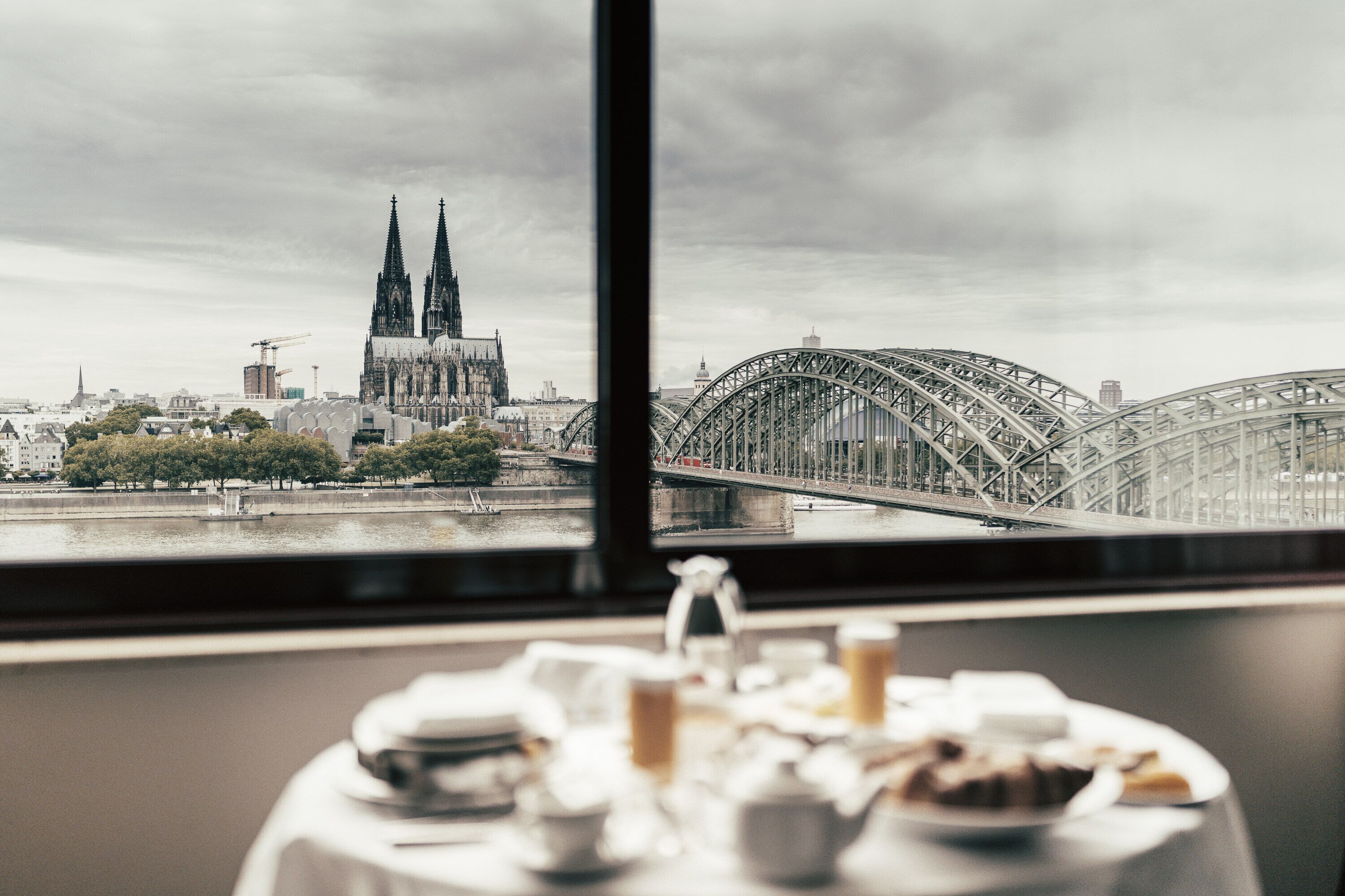 Ein Tisch mit Geschirr und Blick auf ein Dom und eine Brücke.