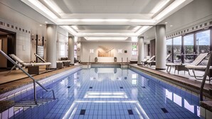 Ein Swimmingpool mit Liegestühlen und Blick auf die Stadt.