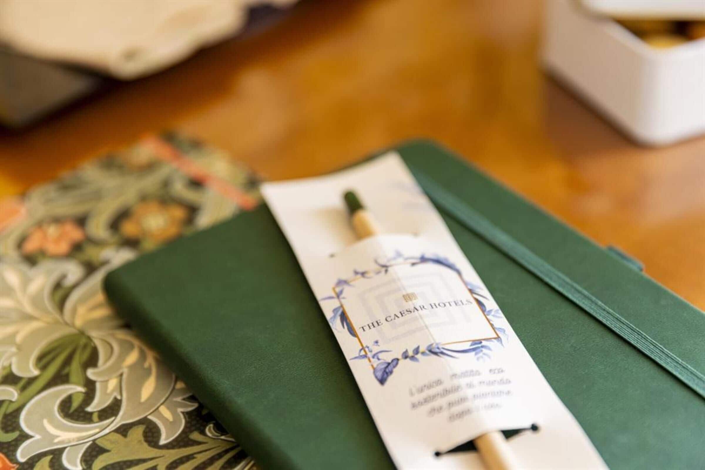 Una libreta verde con una etiqueta que dice "The Caesar Hotels" en la parte superior.
