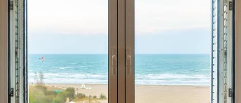 Una ventana con vista a la playa y al océano.