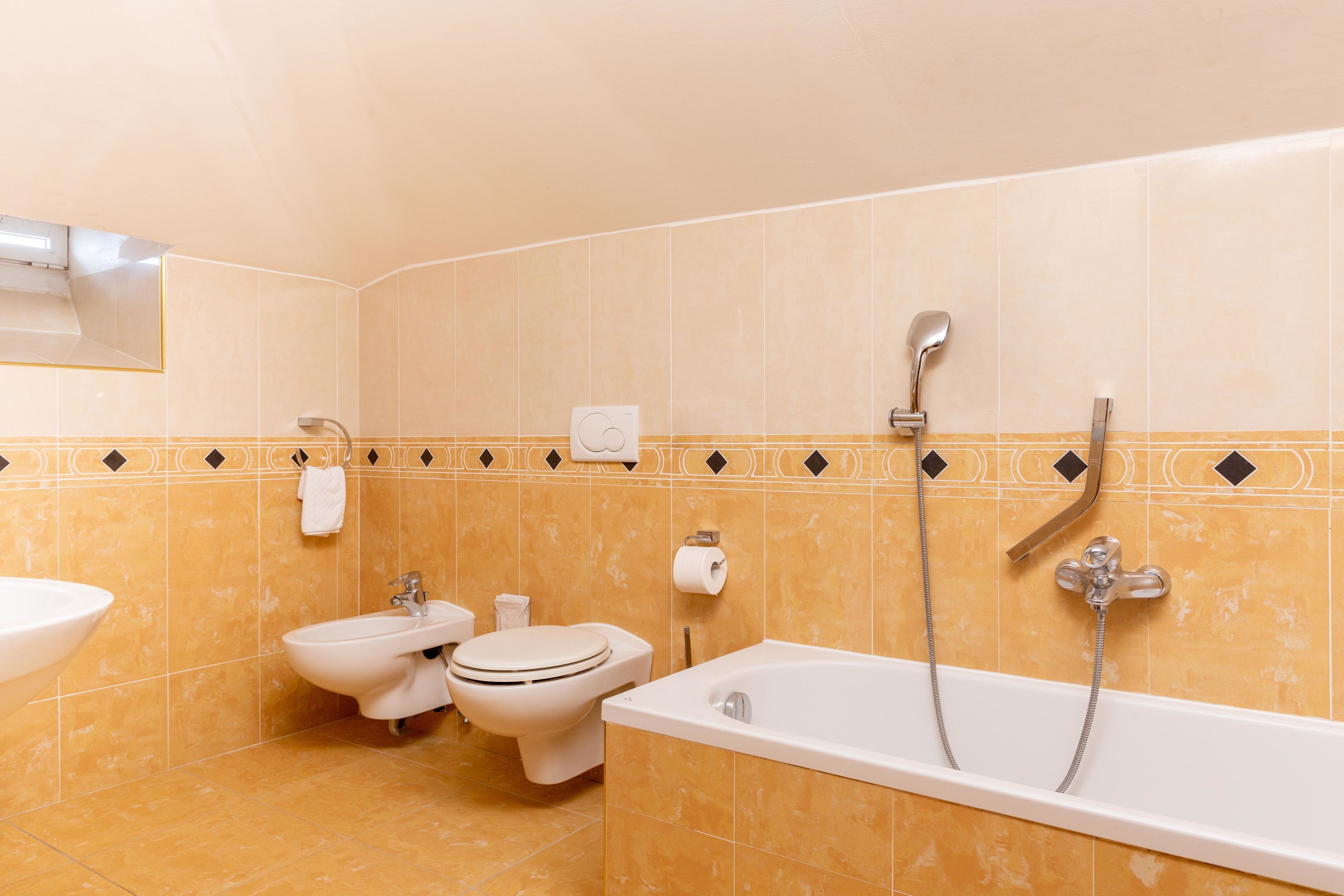 Ein Badezimmer mit Waschbecken, Bidet, Toilette und Badewanne.