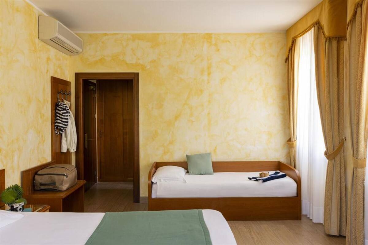 Comfort Triple Room | Minibar, in-room safe, desk, blackout drapes