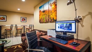 A hotel room with a desk, computer, and a large painting of autumn leaves on the wall. - Best Western Heritage Inn (Vacaville)