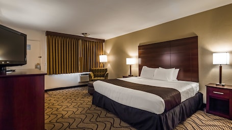 In-room safe, desk, laptop workspace, blackout drapes. Best Western Heritage Inn