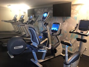 A gym with various exercise equipment including treadmills, elliptical machines, and a stationary bike. - Crowne Plaza Melbourne - Oceanfront by IHG (Indialantic)