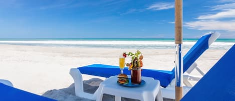 Sur la plage, chaise longue, parasol, serviettes de plage