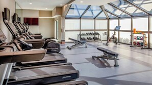 Une salle de sport équipée de tapis de course, d’haltères et d’appareils de musculation.