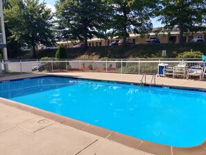 Una piscina al aire libre de temporada, tumbonas