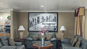 A hotel lobby with two leather sofas, a coffee machine, and a framed welcome sign. - Super 8 by Wyndham New Cumberland (New Cumberland)