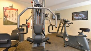 A gym with exercise equipment, a treadmill, and a stationary bike. - Super 8 by Wyndham New Cumberland (New Cumberland)