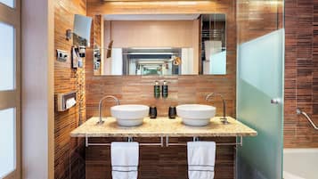 Un baño moderno con dos lavamanos, un espejo grande y cabina de ducha de vidrio.