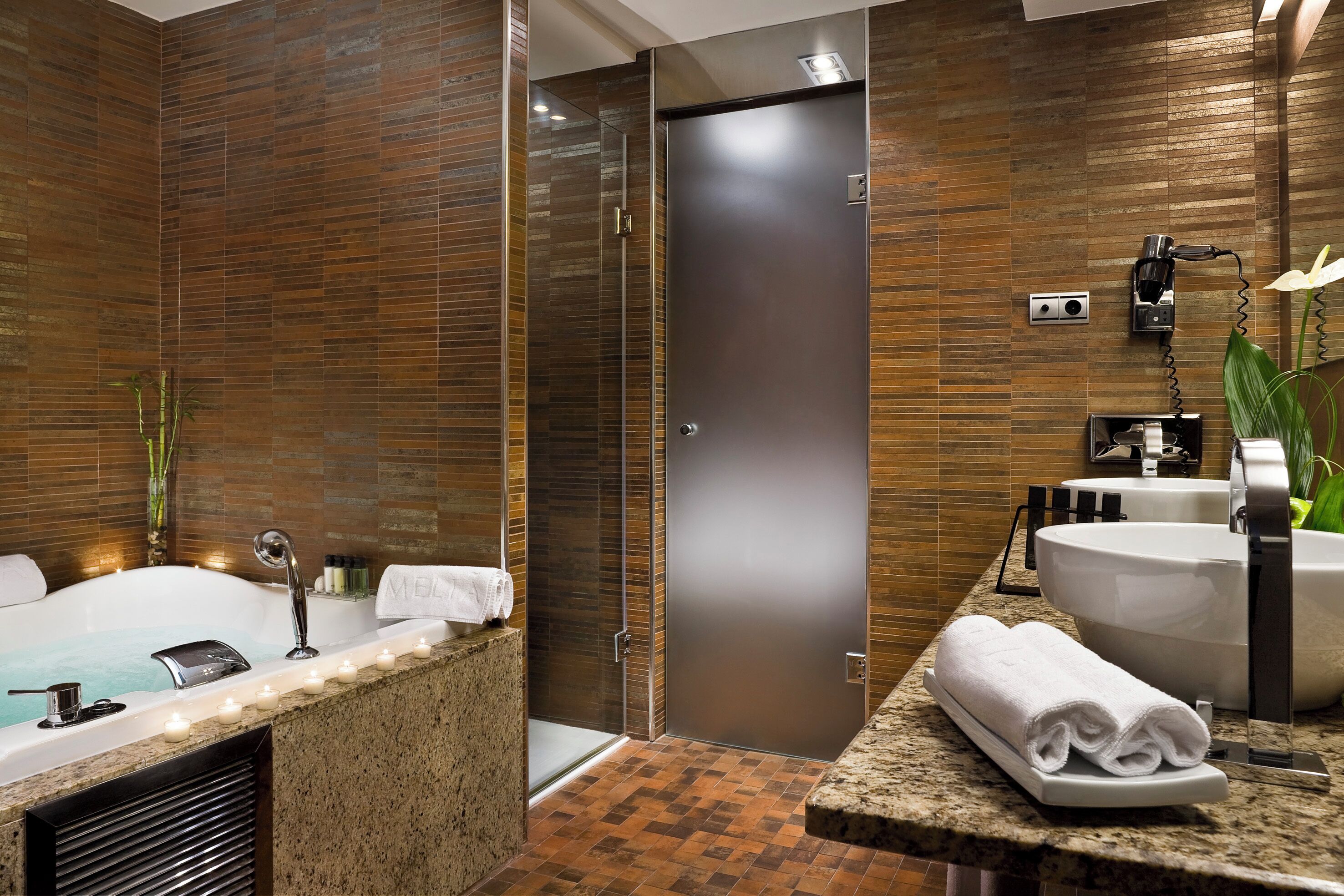 Een moderne badkamer met een groot bad, een aparte douche en een wastafelmeubel met een wastafel en spiegel.