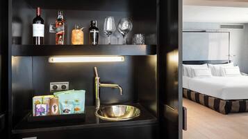 A modern kitchen with a stainless steel sink, a built-in wine cooler, and a breakfast bar area.