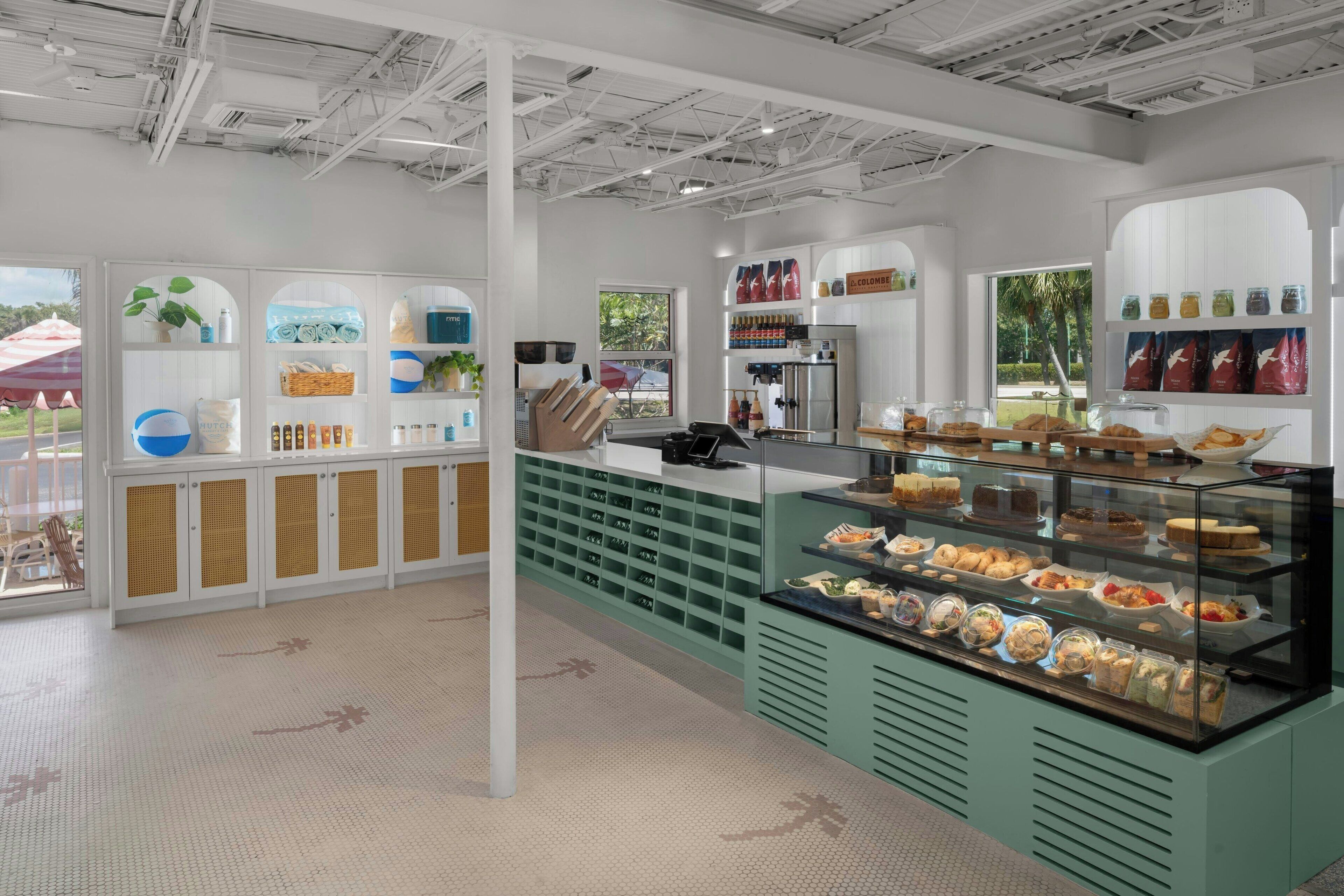 A cafe with a modern interior, featuring a counter with a variety of baked goods and a display case with pastries.