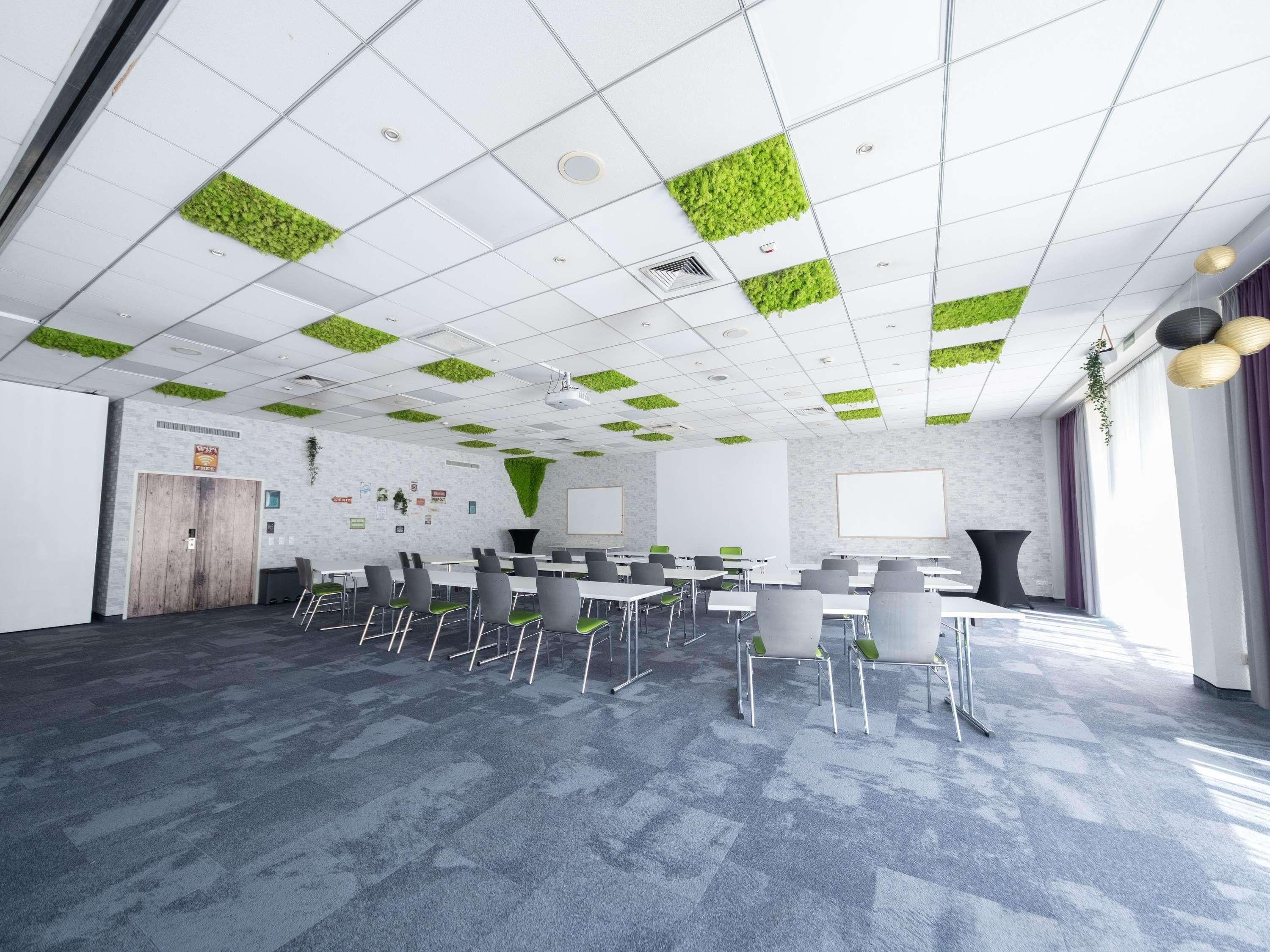 A conference room with a whiteboard, a projector, and a large table with chairs.