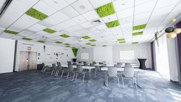 A conference room with a whiteboard, a projector, and a large table with chairs.