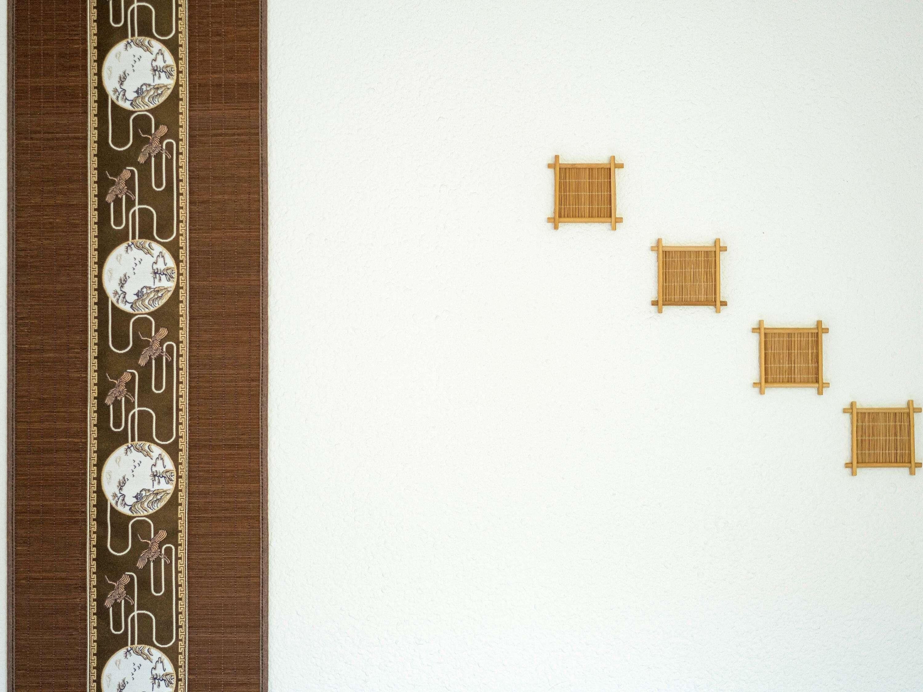 A wall with a decorative border and four square frames.