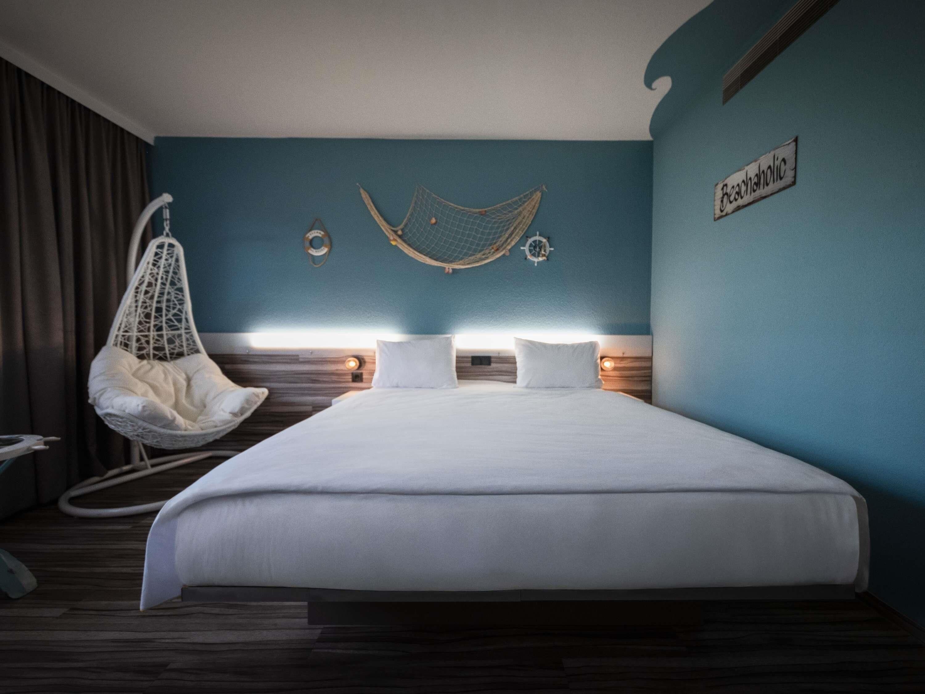 Ein Schlafzimmer mit einem großen Bett, einem Hängestuhl und einer Wandhammock.