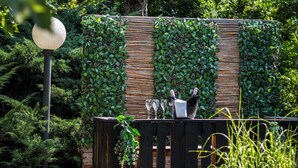 An outdoor patio area with a wooden fence, a table, and chairs. - ibis Styles Linz (Linz)