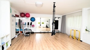 A spacious room with a wooden floor, exercise equipment, and a large window with curtains. - ibis Styles Linz (Linz)