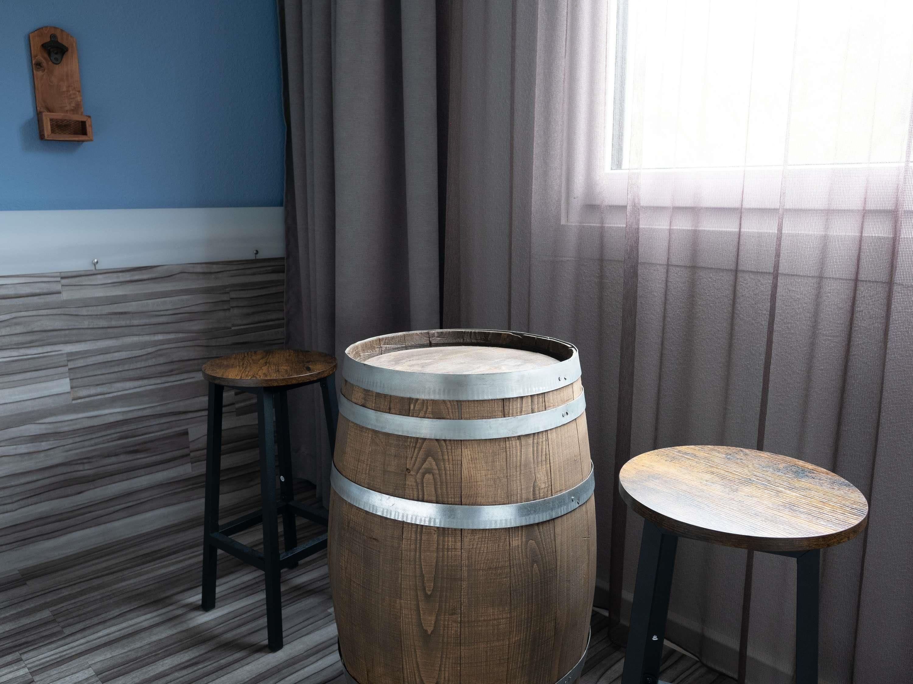 Una habitación con una mesa de caoba, un taburete redondo de madera y una pared azul.