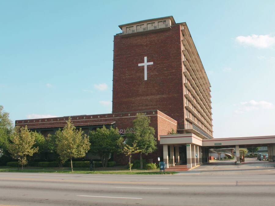 A large brick building with a prominent cross on its facade, likely a church or religious institution.