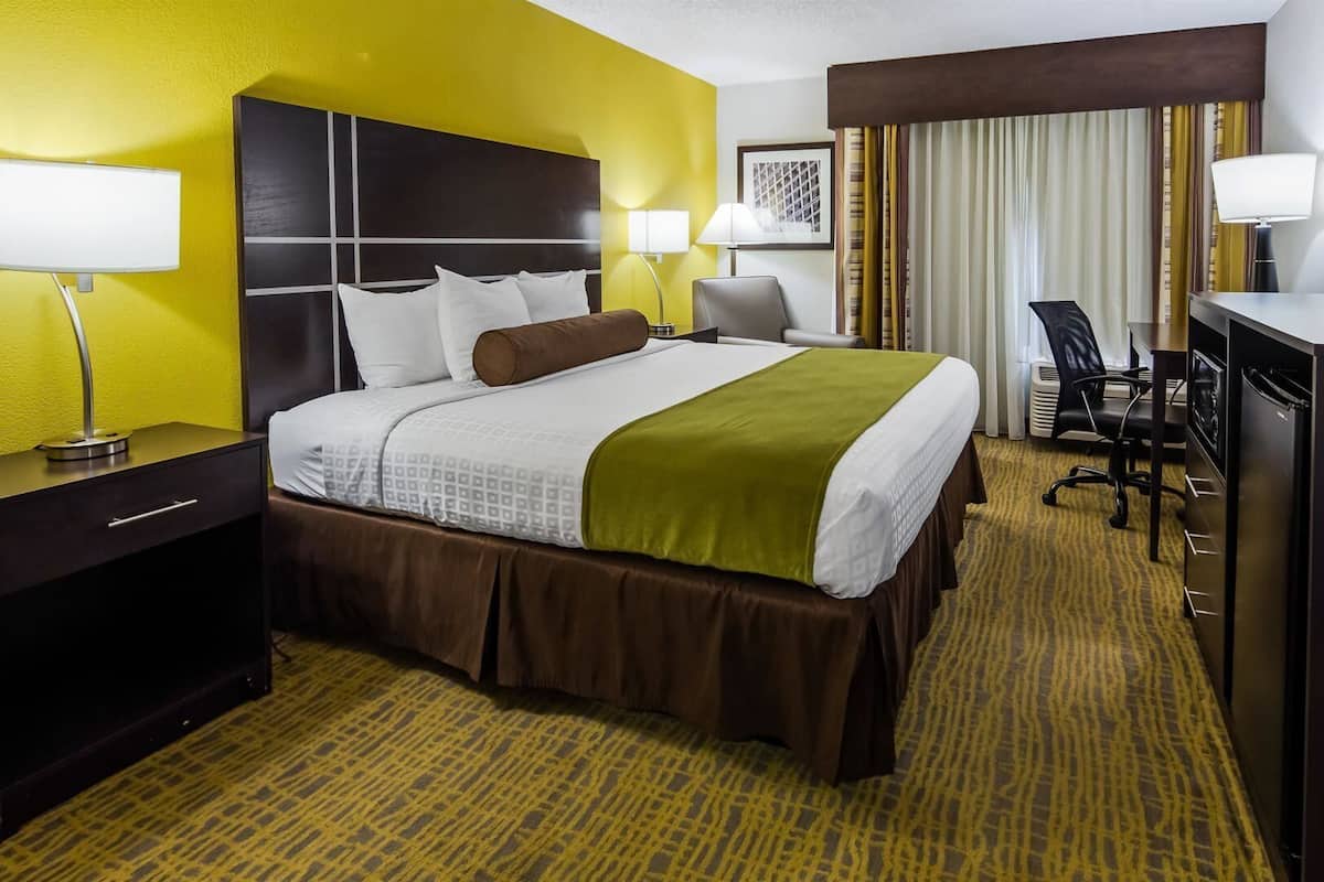 Een hotelkamer met een bed, bureau, stoel en televisie.