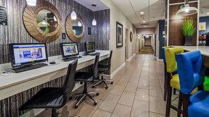 A modern office space with multiple workstations, a long corridor, and a seating area with colorful chairs. - Best Western Plus Hanes Mall Hotel (Winston-Salem)