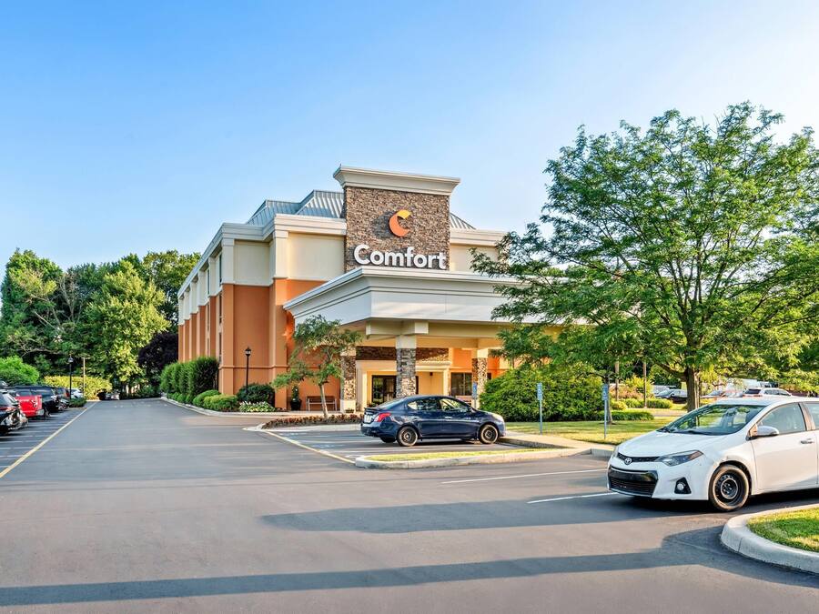 Um hotel Comfort com um estacionamento e alguns carros.