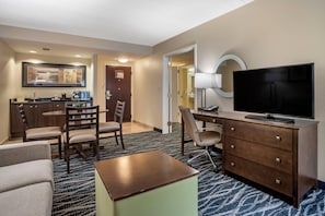 Habitación de hotel con comedor, televisor y escritorio.