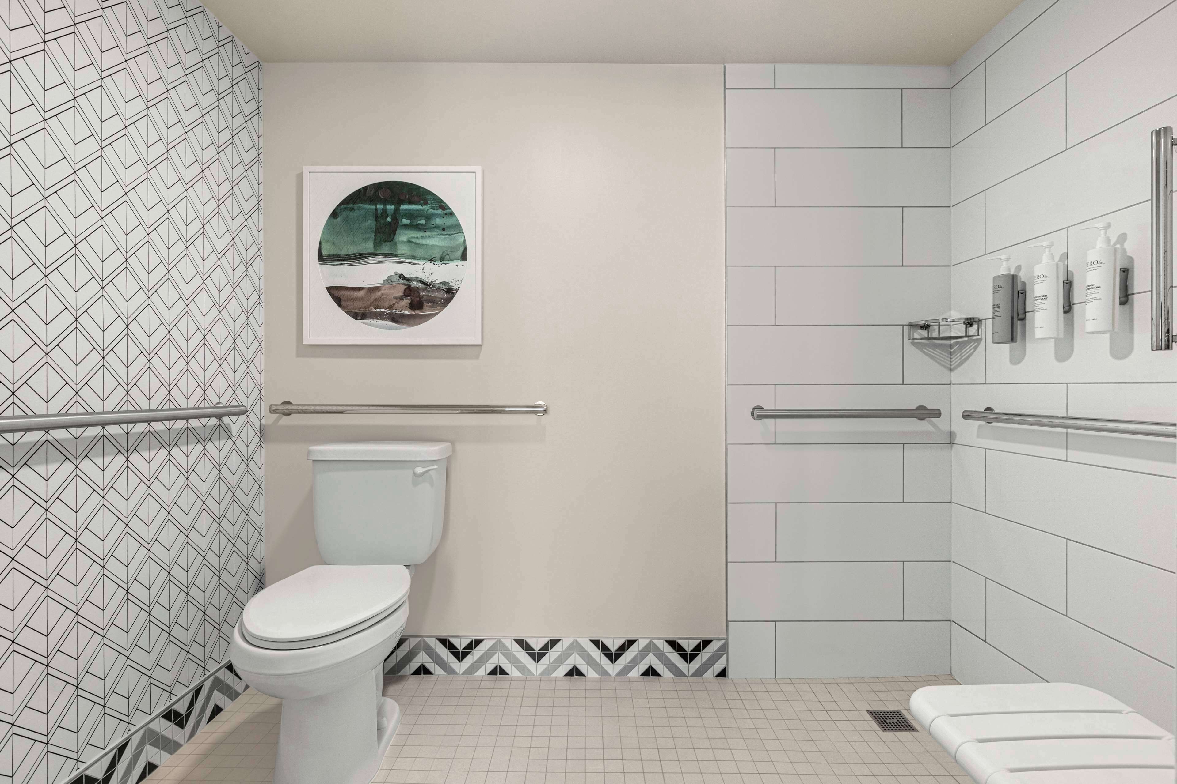 A modern bathroom with a toilet, a shower area, and a sink with toiletries.