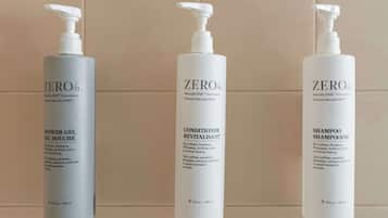 Three bottles of ZERO% products: shower gel, conditioner, and shampoo.