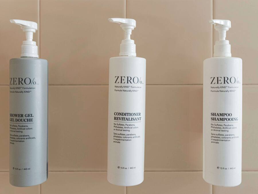 Three bottles of ZERO% products: shower gel, conditioner, and shampoo.