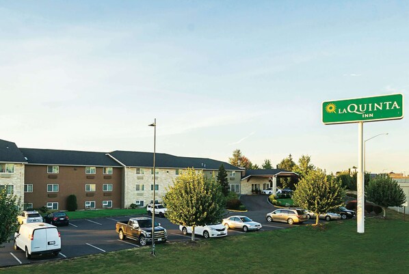 Un estacionamiento con varios autos y un edificio identificado como 'La Quinta Inn'.