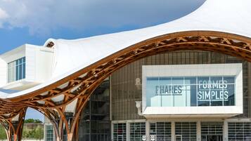 A modern building with a unique curved roof structure and large glass windows.