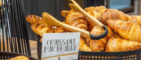 Una bandeja de cruasanes y un cartel que indica 'Croissant Pur Beurre'.