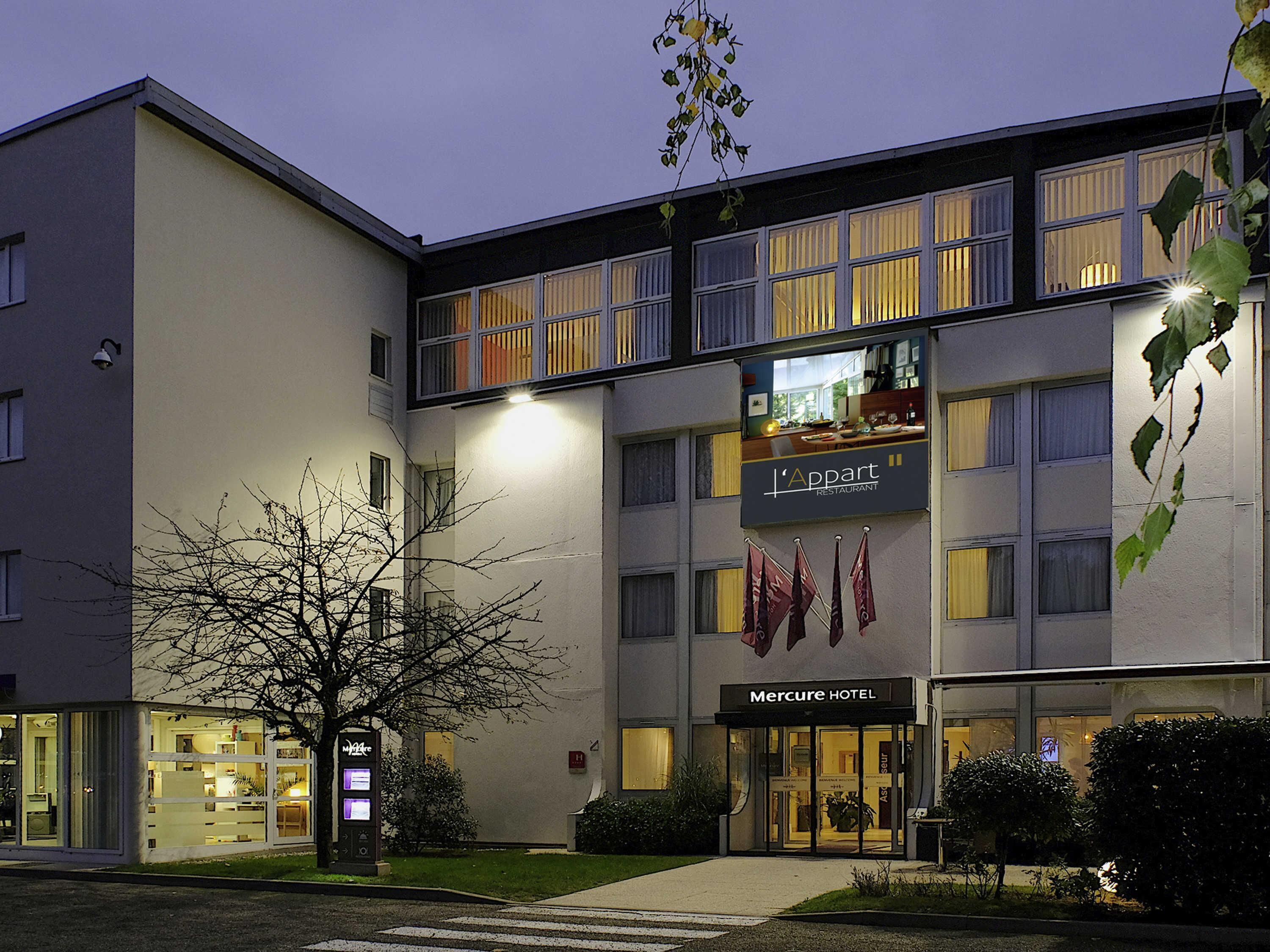 A hotel with a modern facade, a restaurant sign, and a visible entrance.