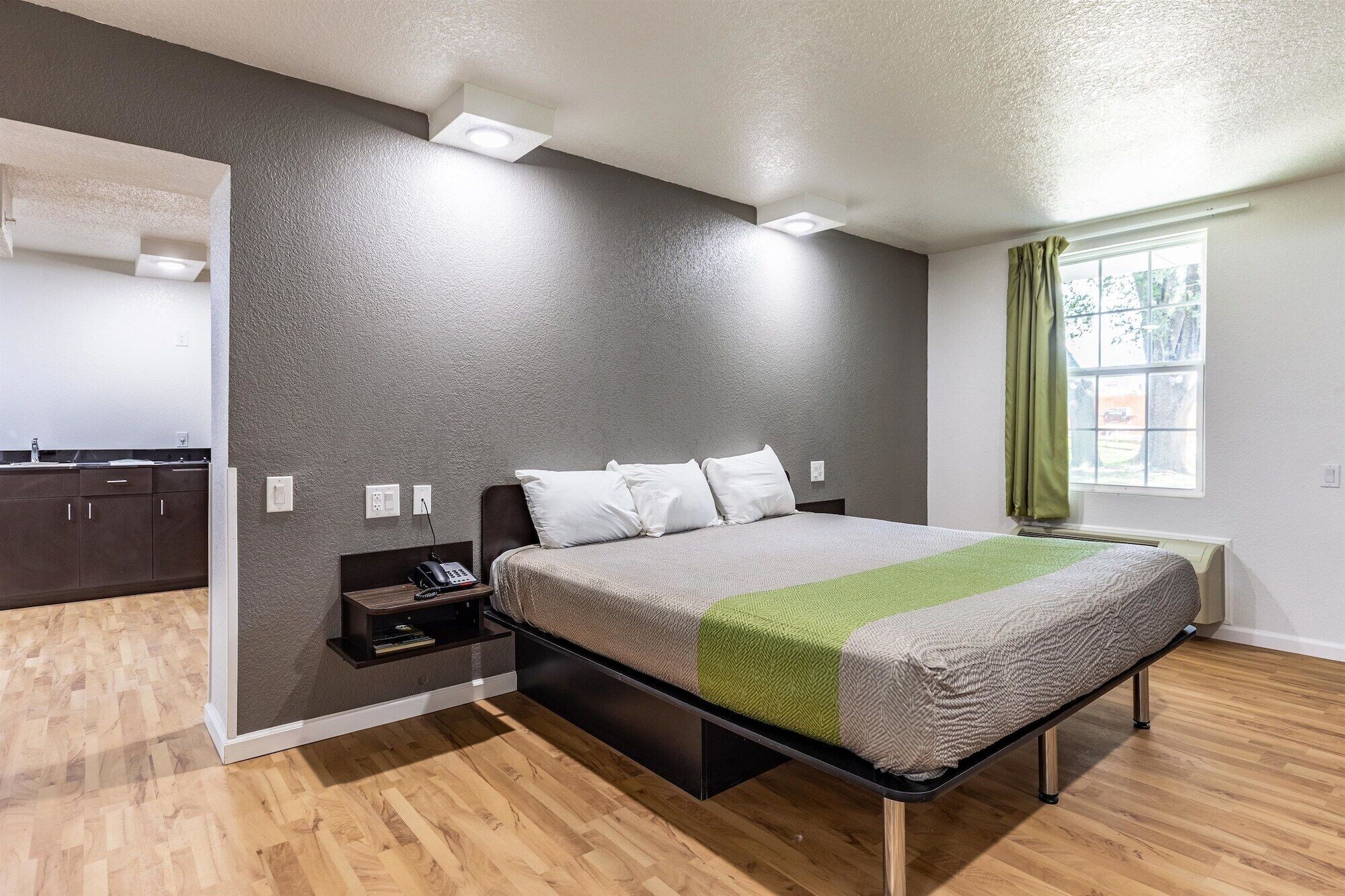 A modern bedroom with a bed, bedside table, and a built-in wardrobe.
