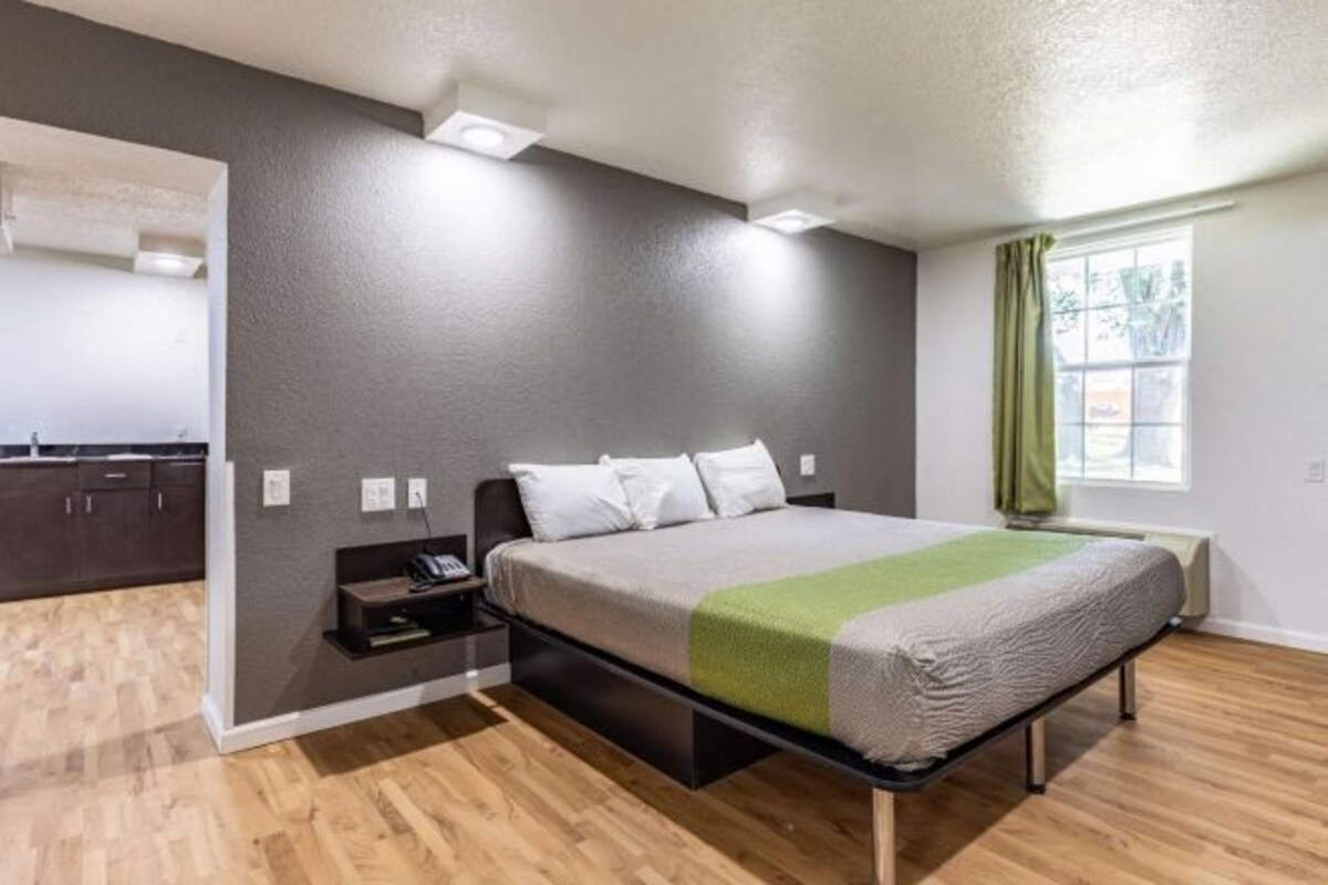 Una camera da letto moderna con un letto, un comodino e una panca integrata.