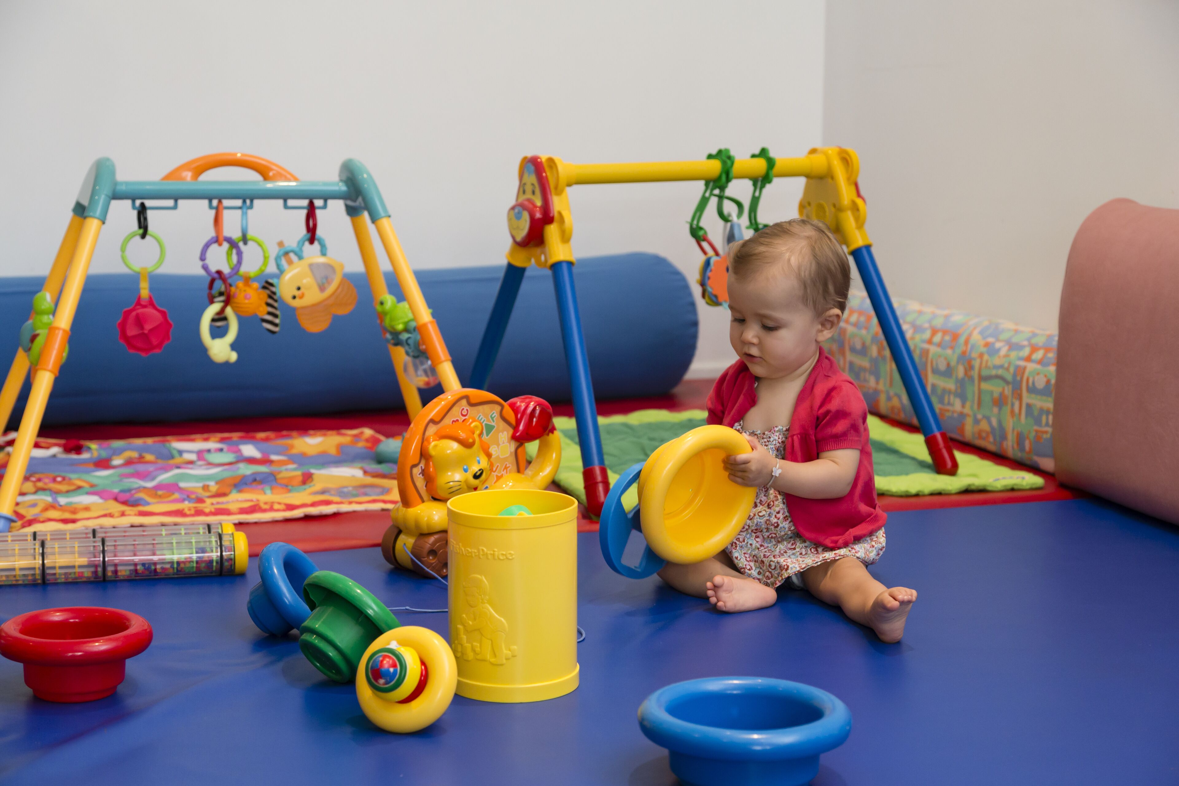 A child playing with toys on a blue play mat.