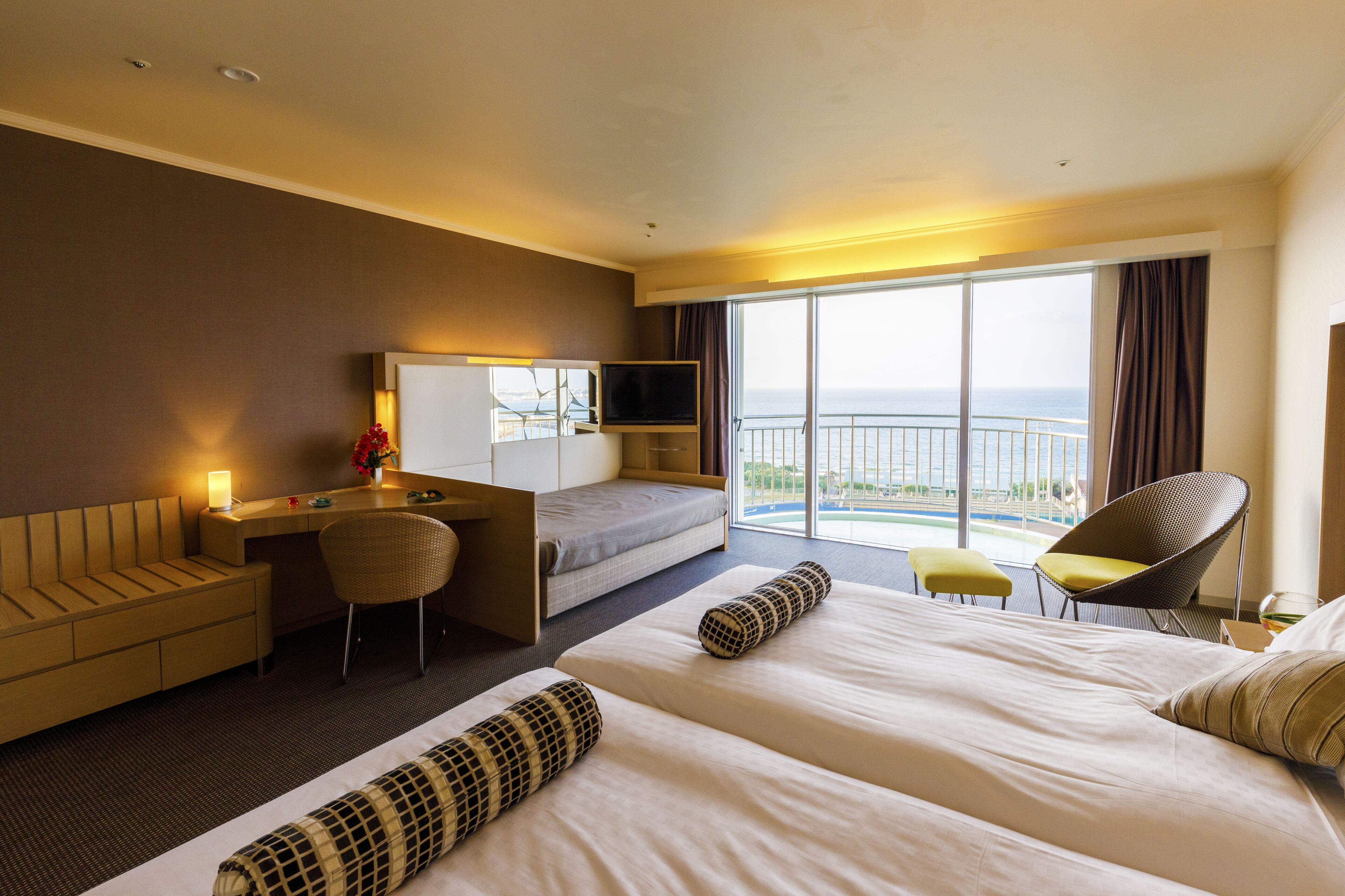 A hotel room with a bed, a desk, a chair, and a TV.