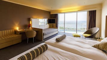A hotel room with a bed, a desk, a chair, and a TV.