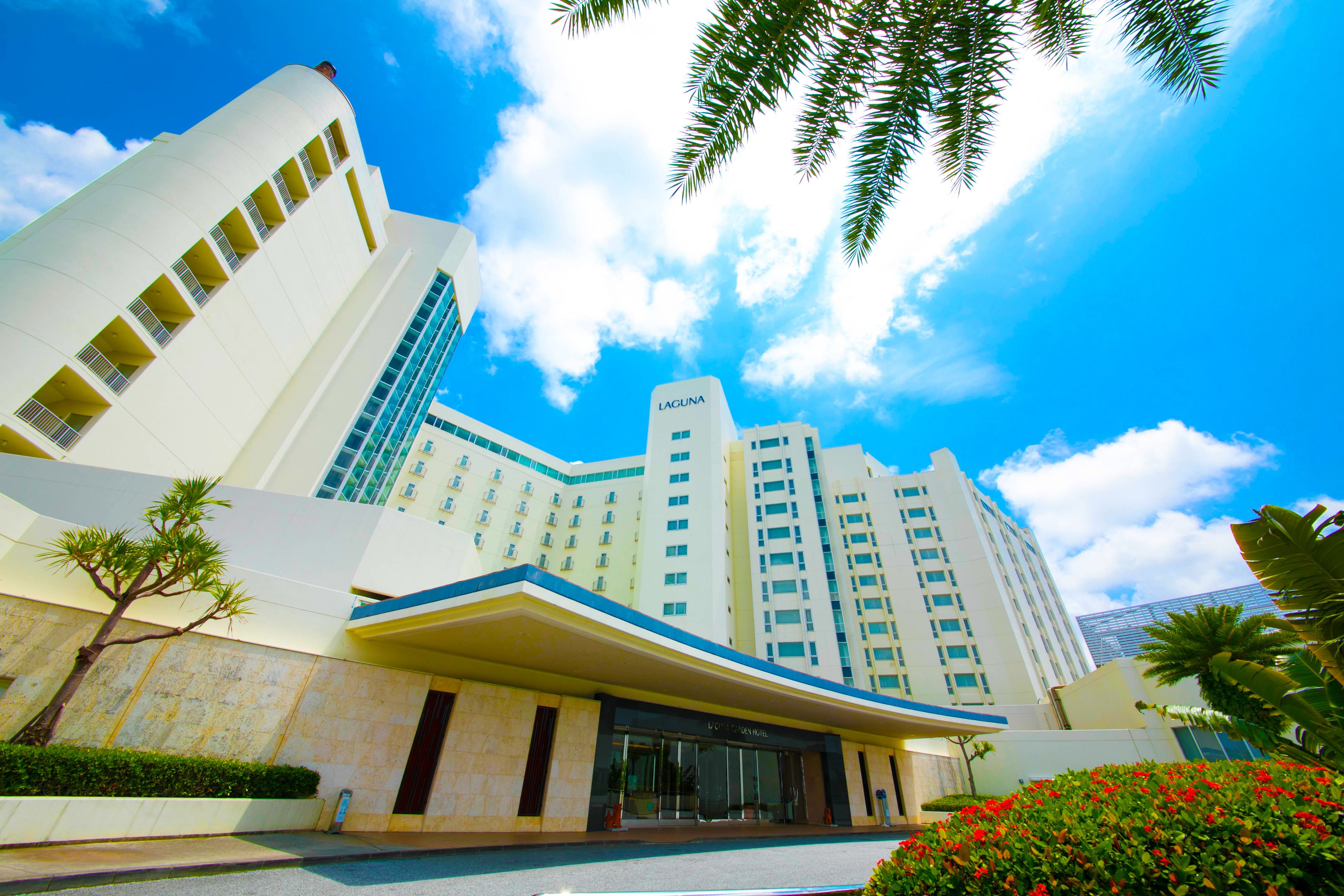 A modern hotel with a curved facade, multiple balconies, and a prominent "LACUNA" sign.