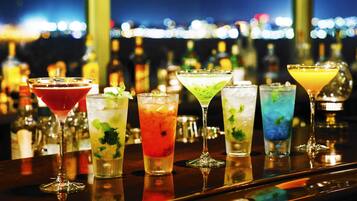 A bar with various colorful cocktails and bottles in the background.