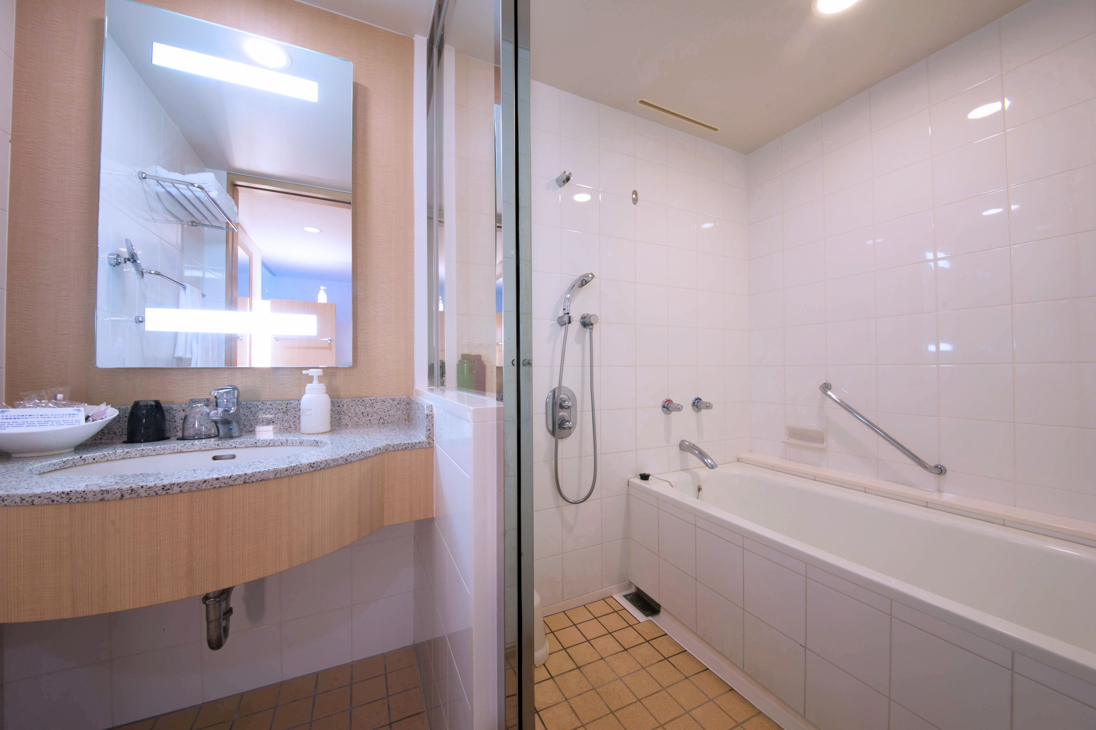 Un bagno moderno con box doccia in vetro, vasca da bagno e mobile lavabo con lavandino e specchio.