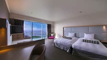 A hotel room with two beds, a desk, a chair, and a TV.