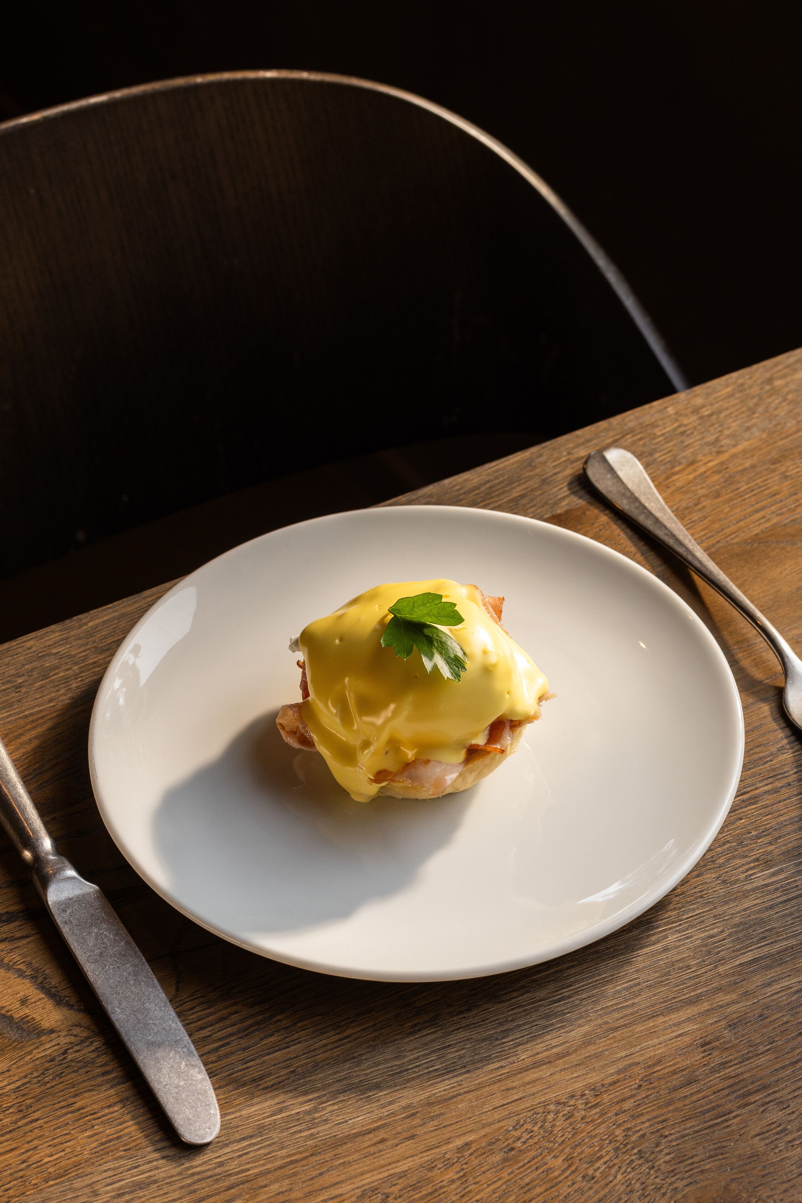 Un plato con un sándwich sobre una mesa de madera.