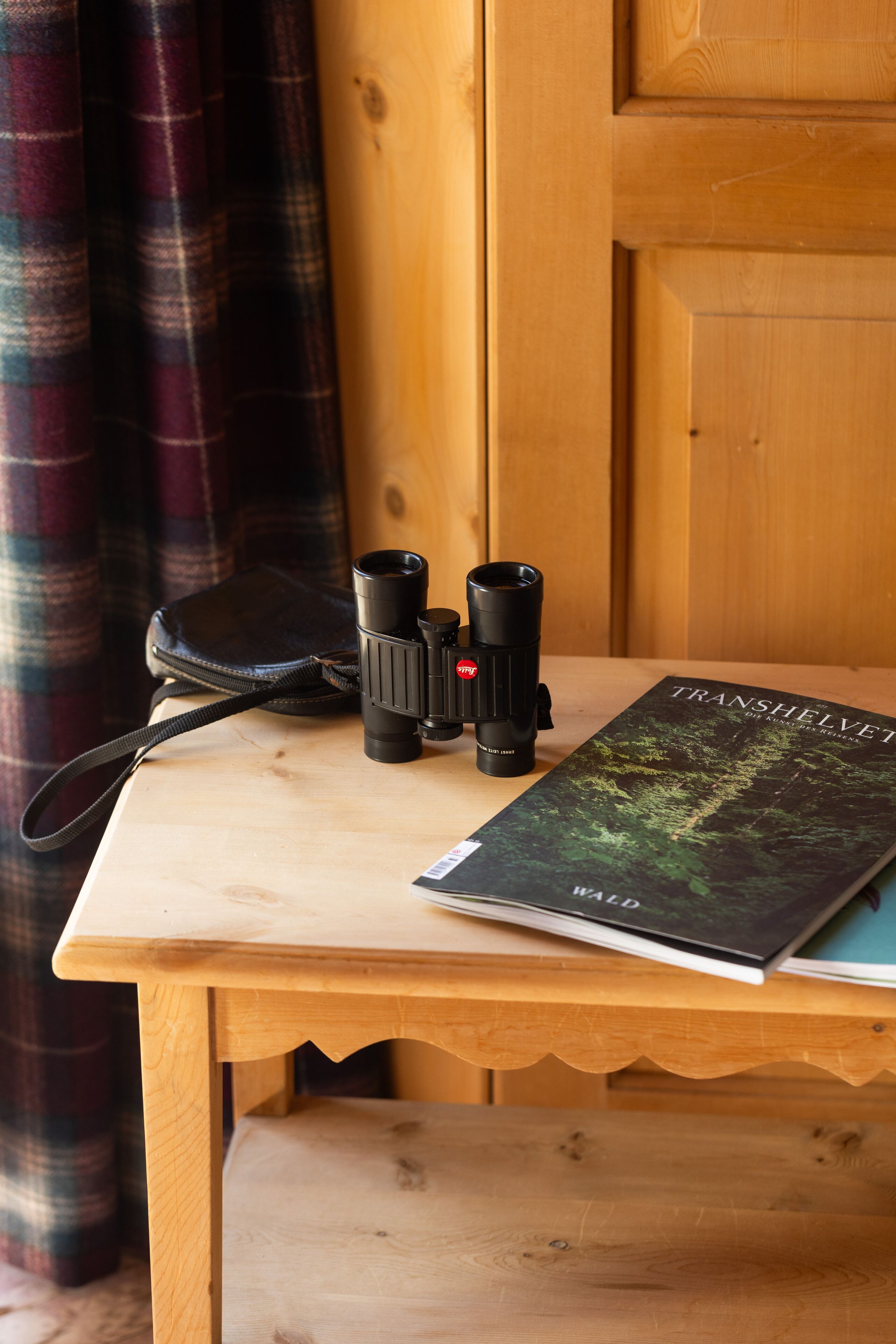 A wooden table with a camera and a book titled "TRANSHELVET" on it.